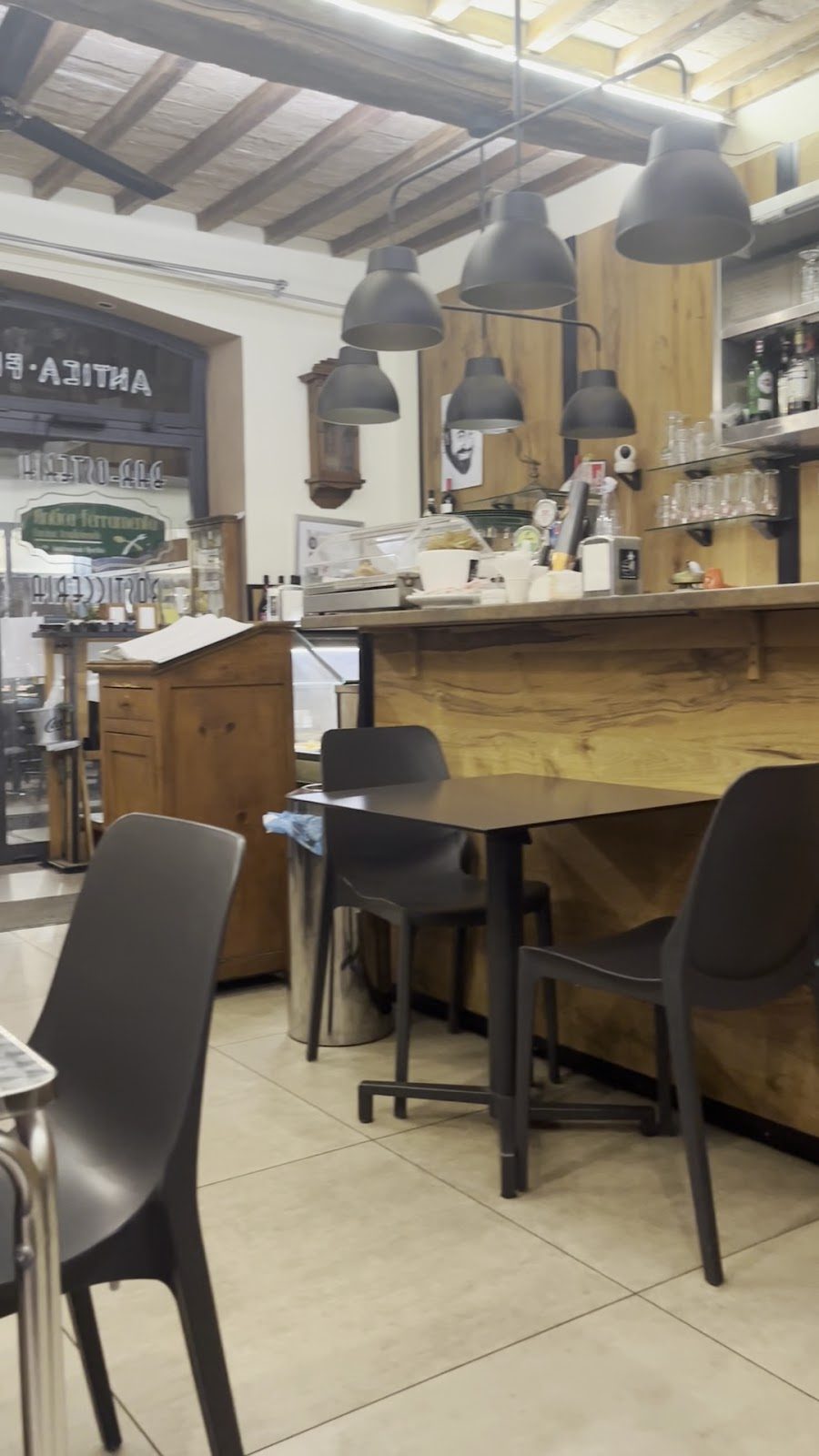 Lampade in ferro nero sospese sopra i tavoli dell'osteria